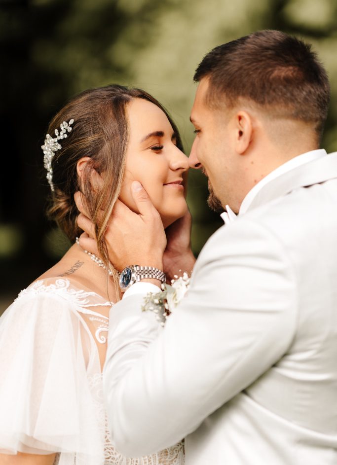 Ein verliebtes Paar in eleganter Hochzeitskleidung, das sich zärtlich ansieht.