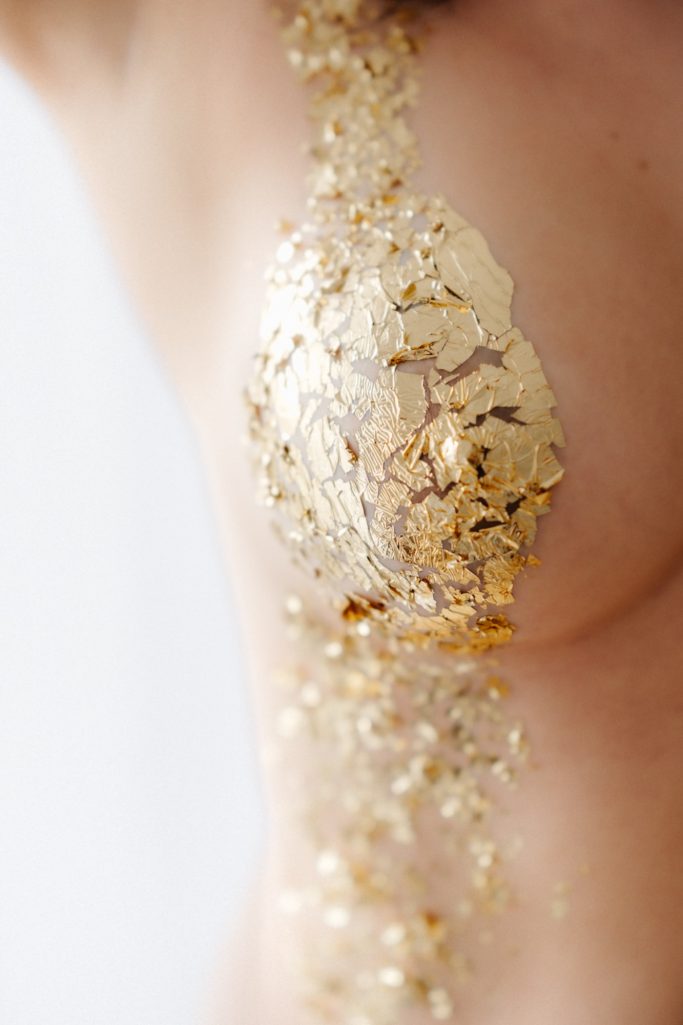 Goldfolien schimmern entlang einer Hautstelle, die einen eleganten und luxuriösen Effekt zeigt.