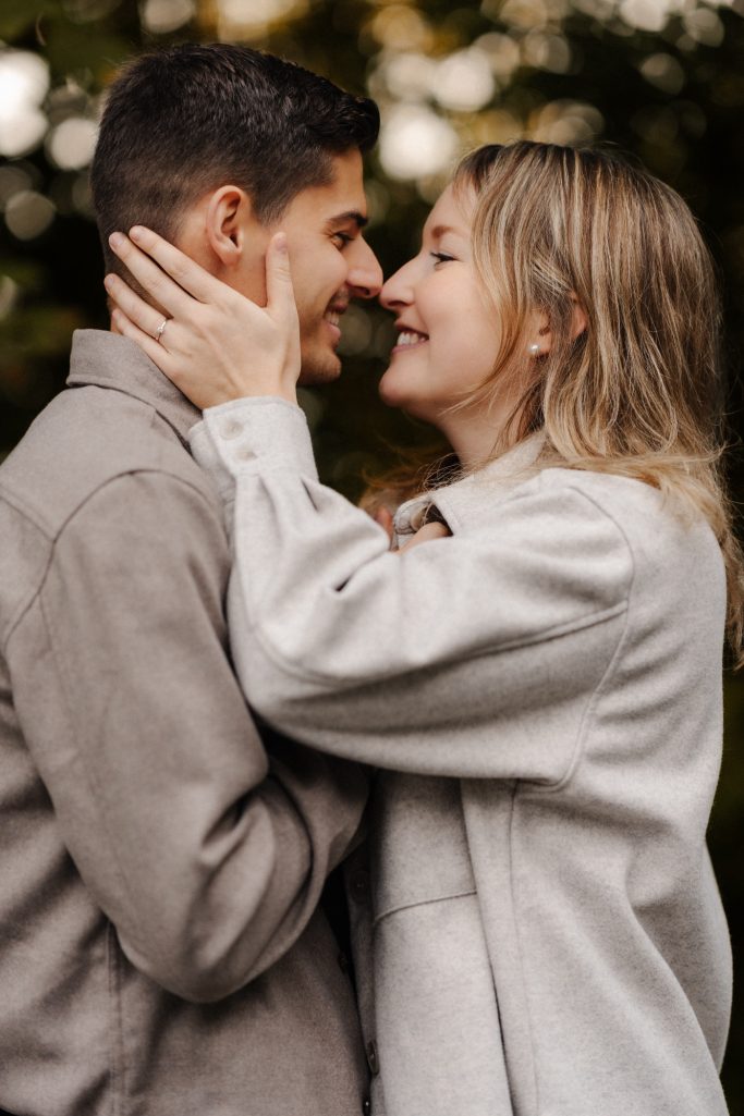 Ein Paar lächelt sich an und berührt sich sanft im Freien.